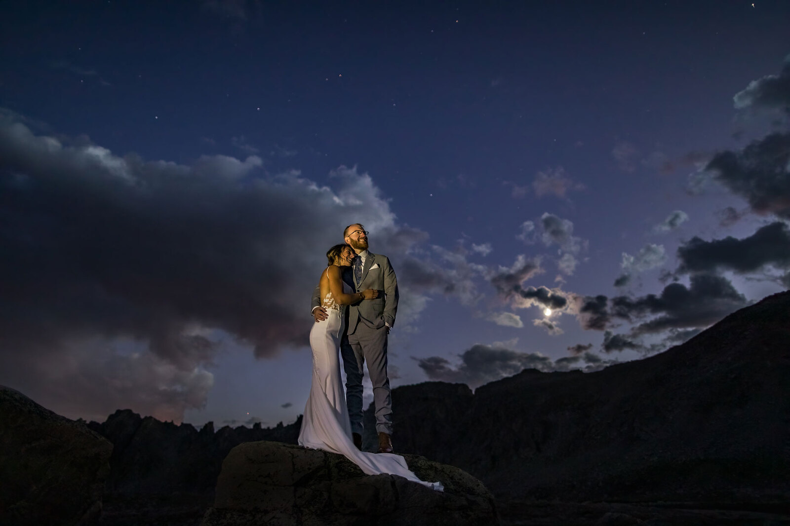 Wedding photo of bride and groom under the moon and stars.