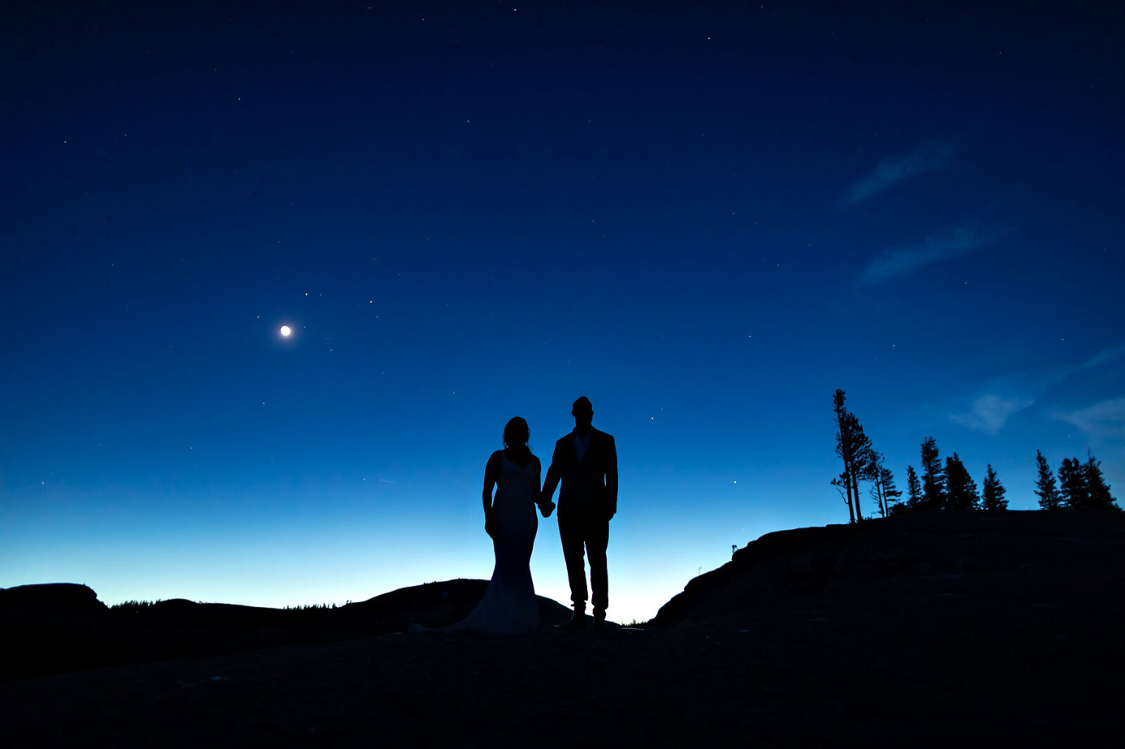 Elopement photo of bride and groom under the moon and stars.