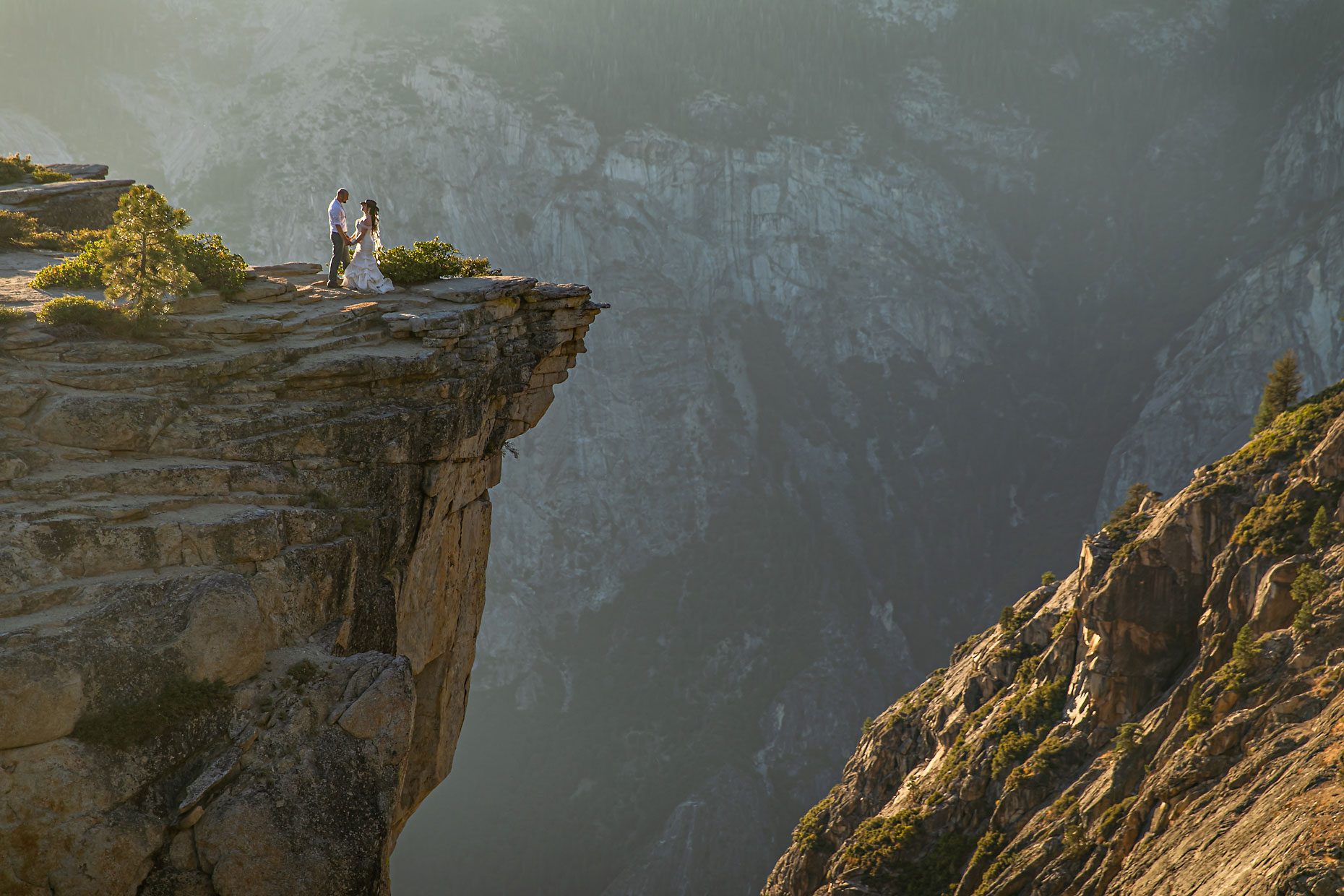 Couple gets wedding photography in Yosemite at Taft Point at sunset.