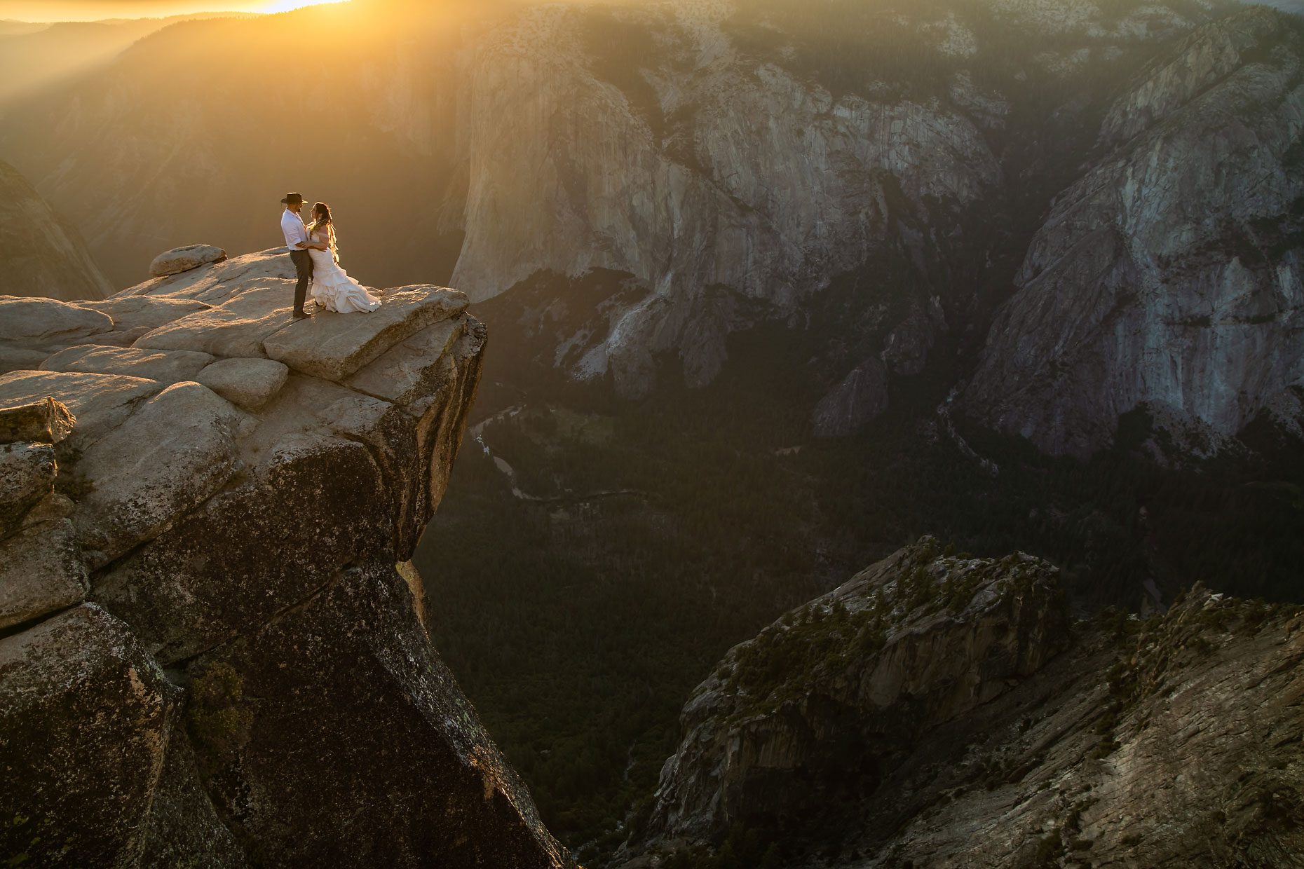 Couple gets wedding photography in Yosemite at Taft Point at sunset.