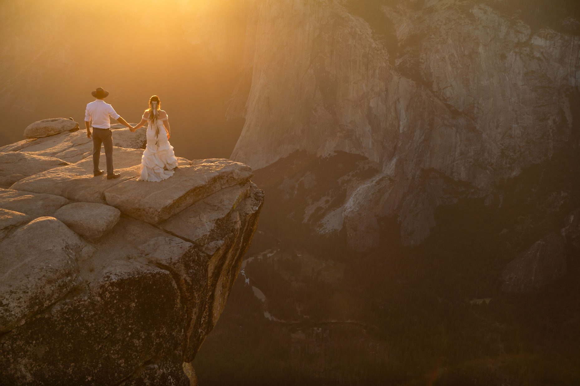 Couple gets wedding photography in Yosemite at Taft Point at sunset.