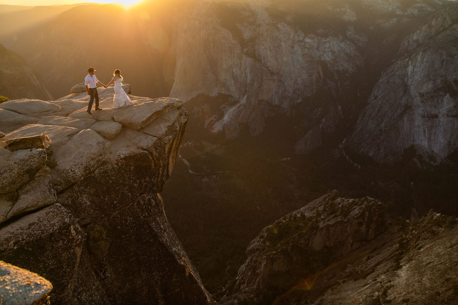 Couple gets wedding photography in Yosemite at Taft Point at sunset.