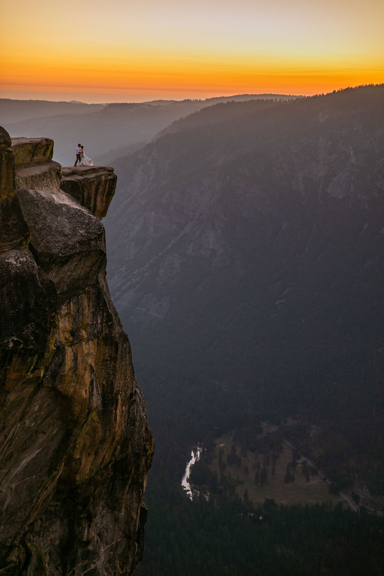 Couple gets wedding photography in Yosemite at Taft Point at sunset.