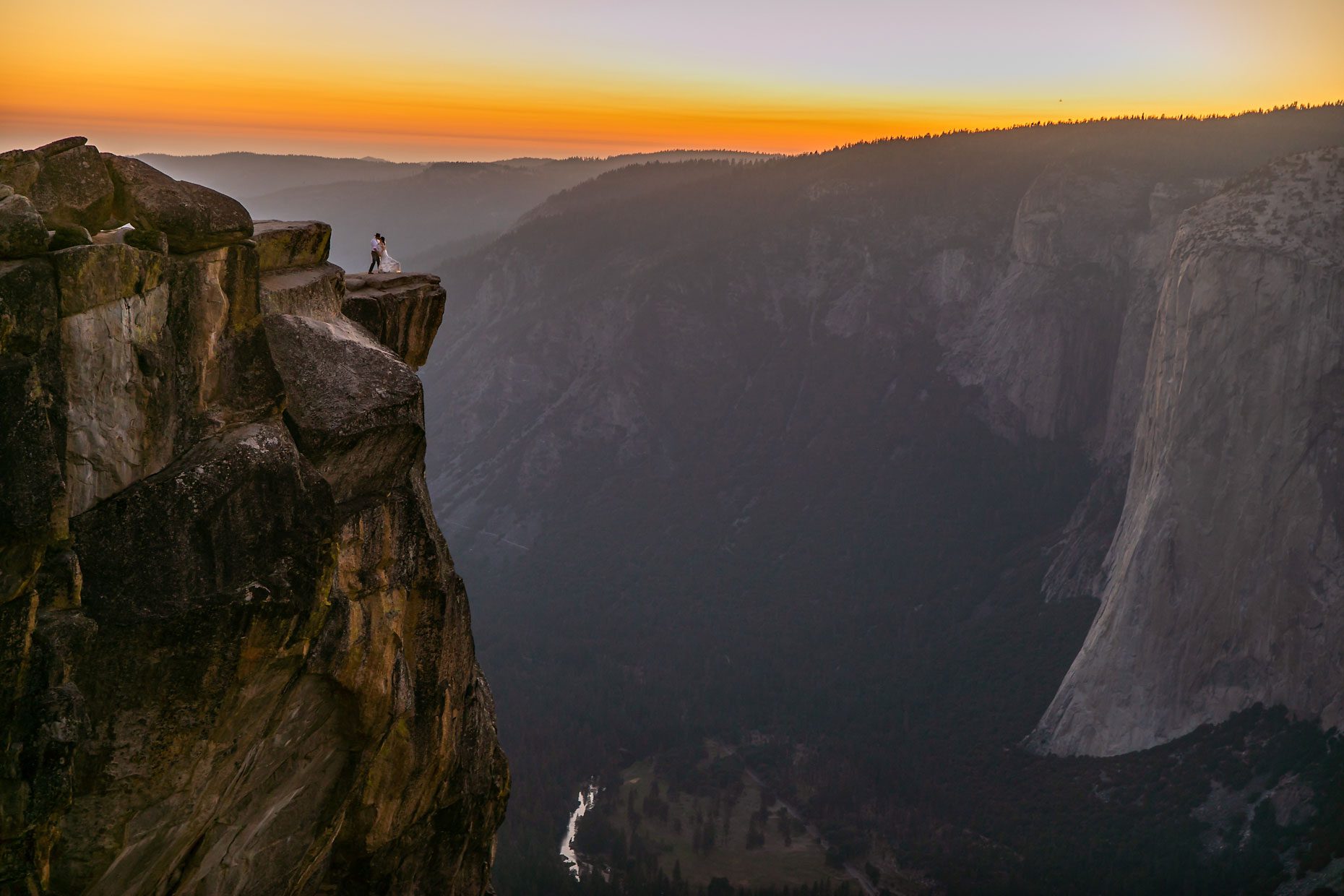 Couple gets wedding photography in Yosemite at Taft Point at sunset.