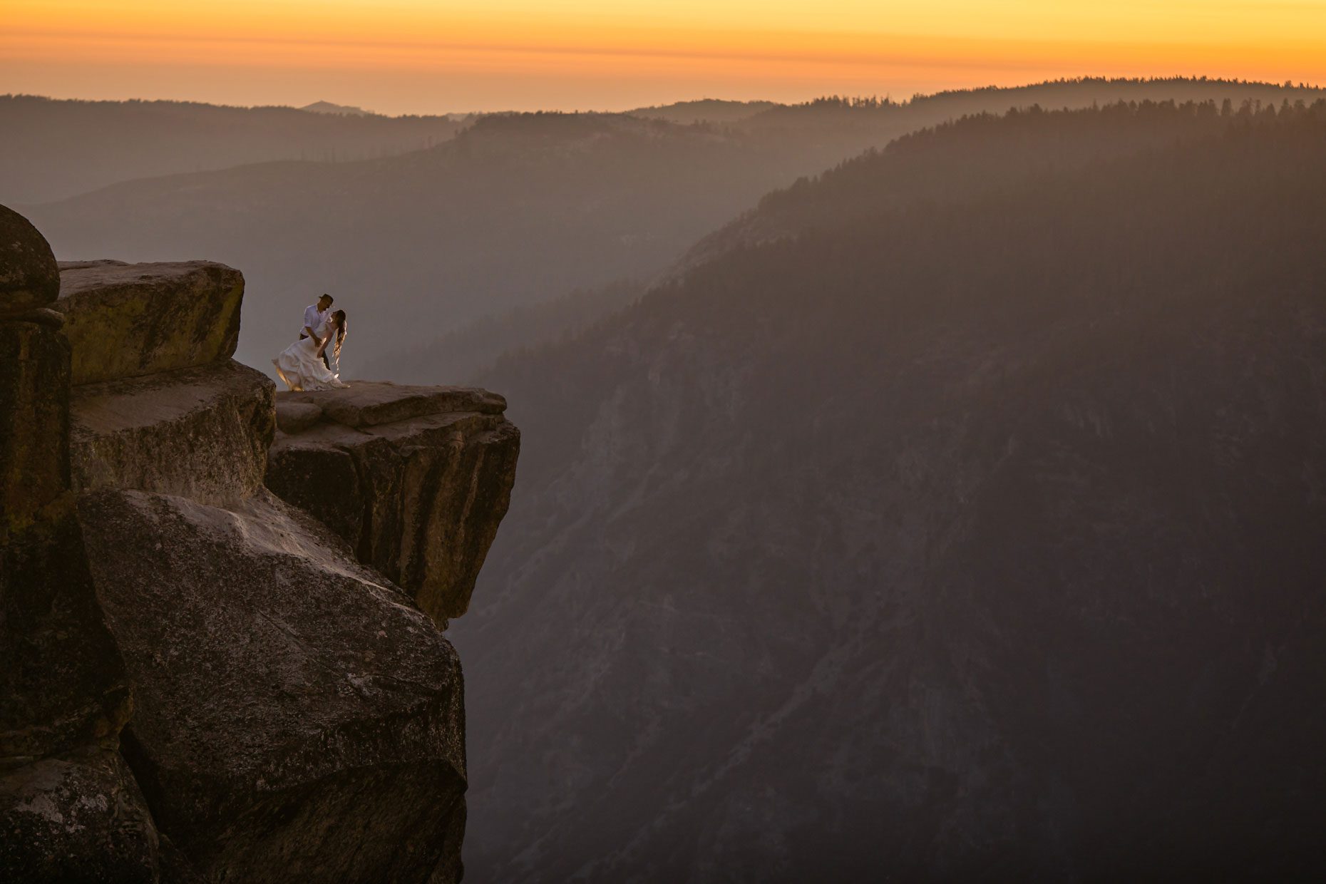 Couple gets wedding photography in Yosemite at Taft Point at sunset.
