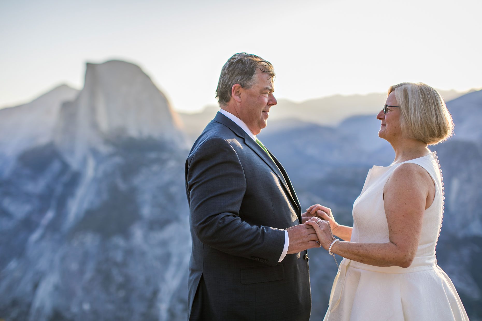 Couple gets wedding photography in Yosemite National Park at Glacier Point at sunrise.