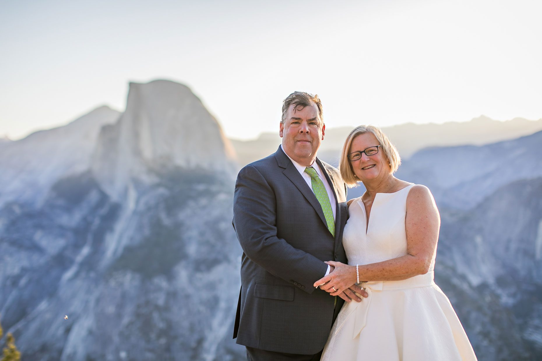 Couple gets wedding photography in Yosemite National Park at Glacier Point at sunrise.