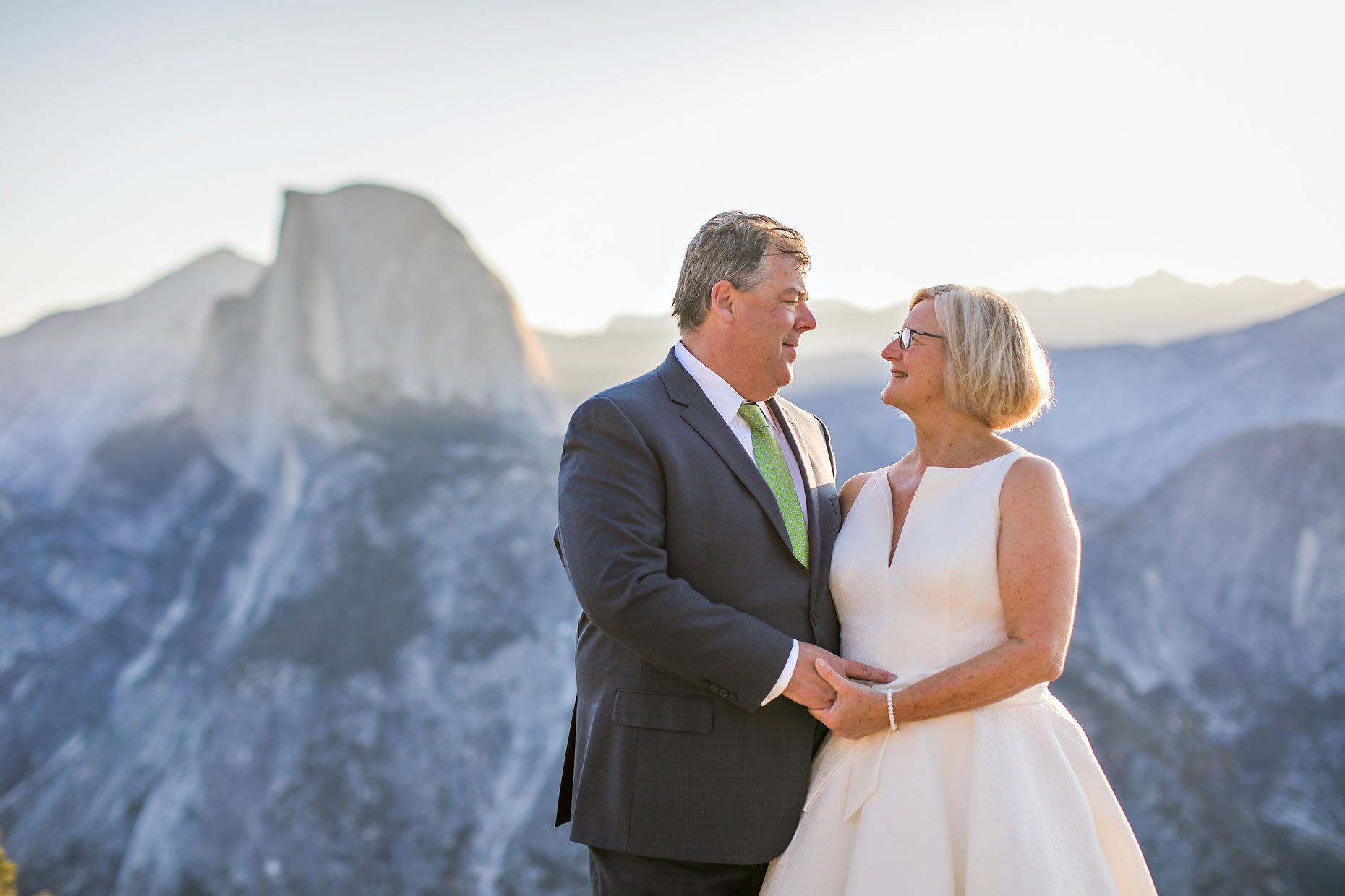 Couple gets wedding photography in Yosemite National Park at Glacier Point at sunrise.