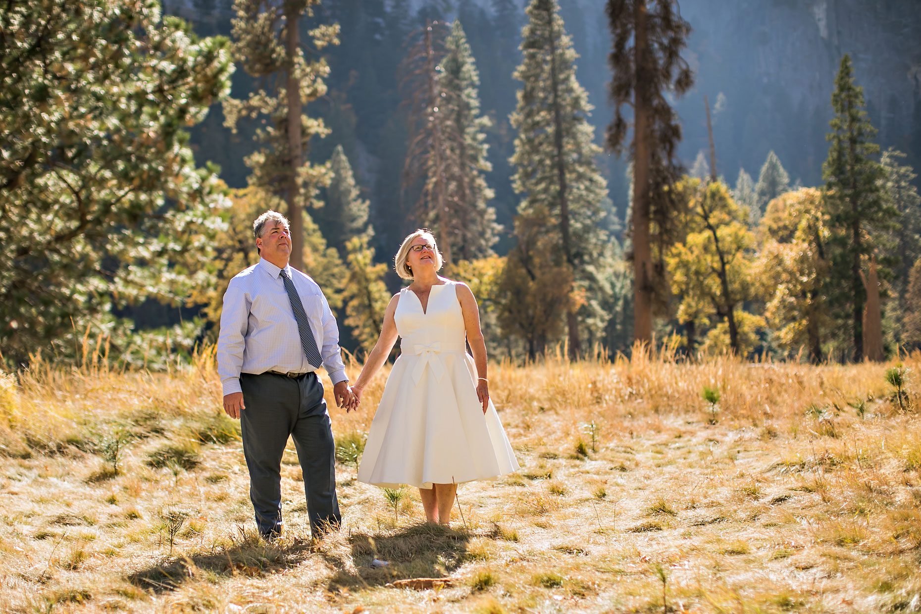 Wedding couple gets photographer to capture photos of them in Yosemite meadow.