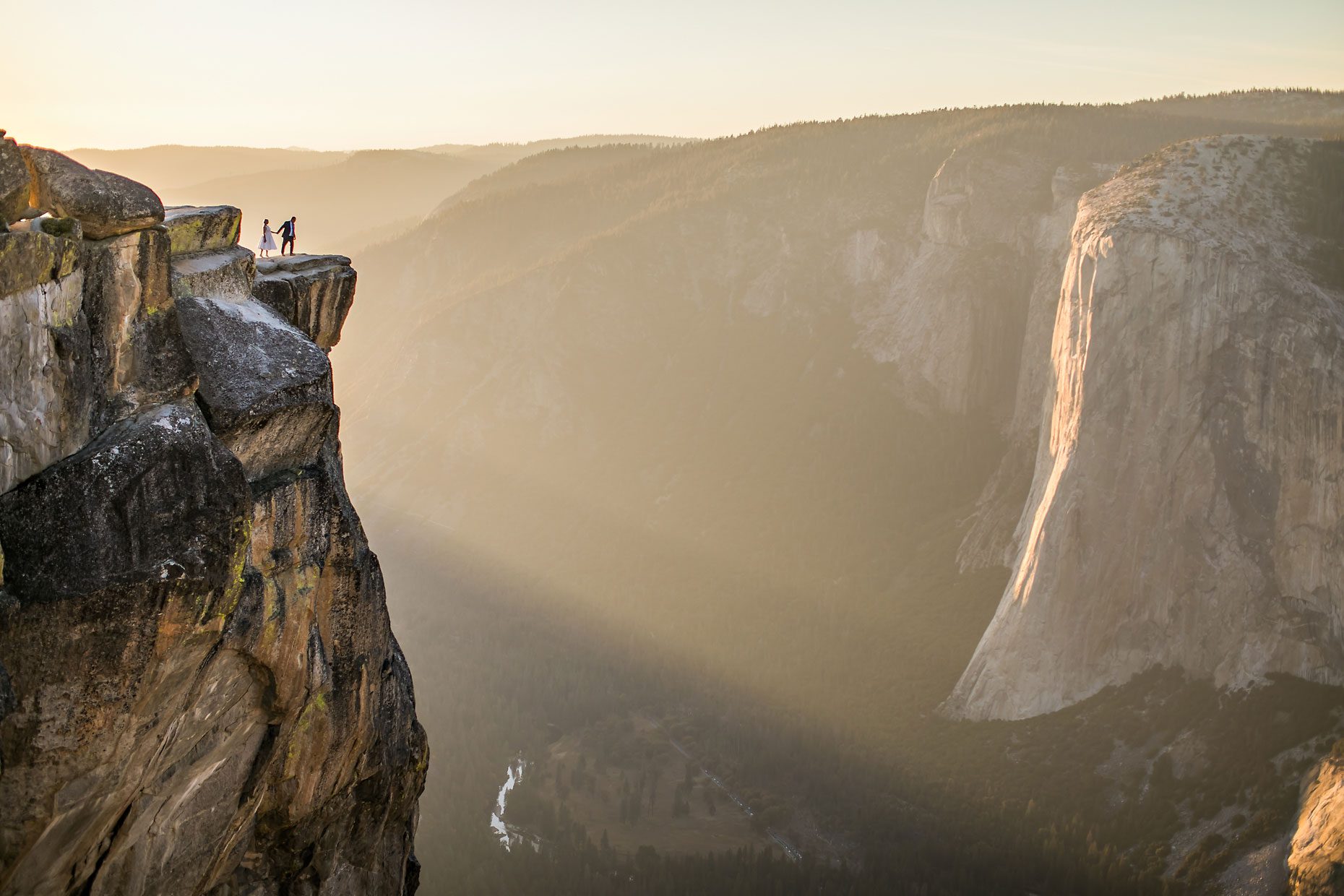 Wedding couple in love at Taft Point in Yosemite for adventure session photography at sunset.