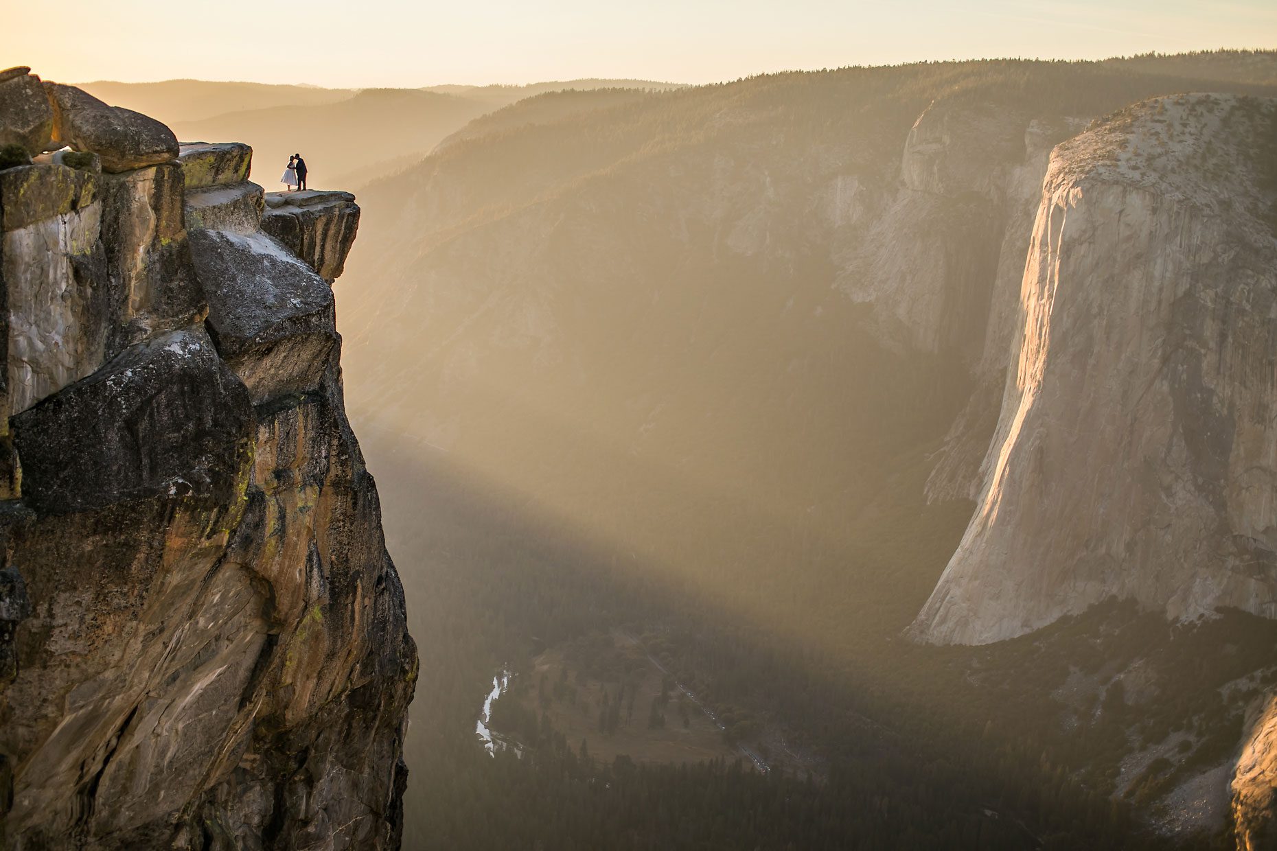 Wedding couple in love at Taft Point in Yosemite for adventure session photography at sunset.