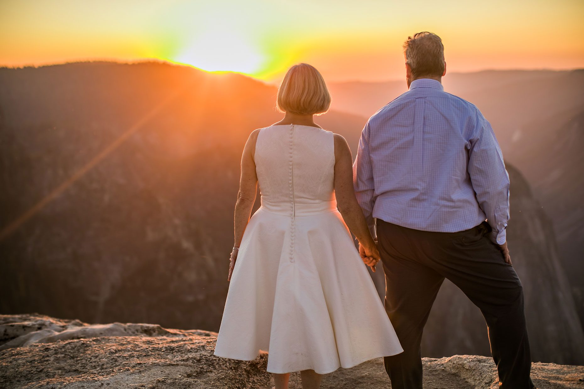 Wedding couple in love at Taft Point in Yosemite for adventure session photography at sunset.
