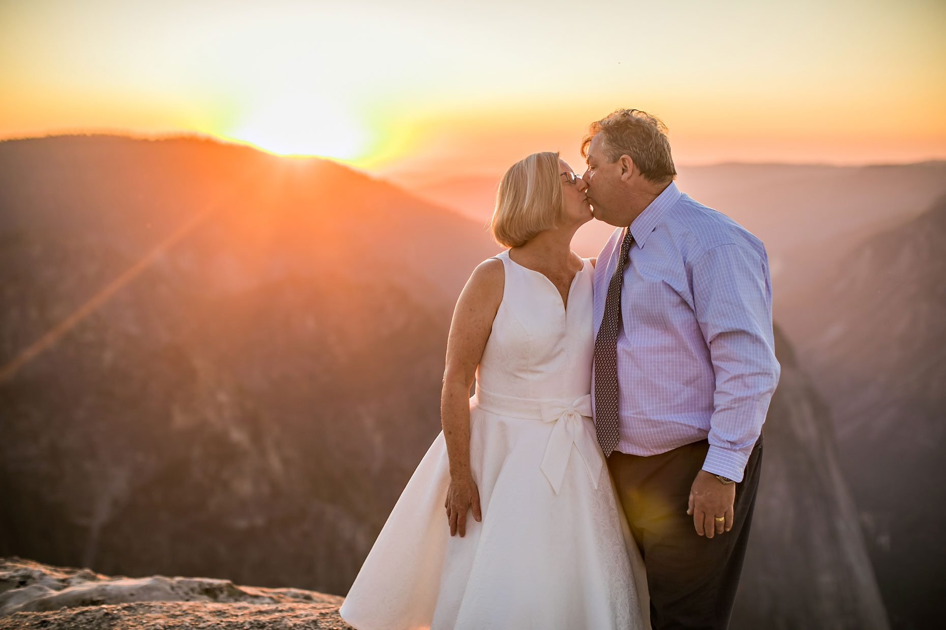 Wedding couple in love at Taft Point in Yosemite for adventure session photography at sunset.