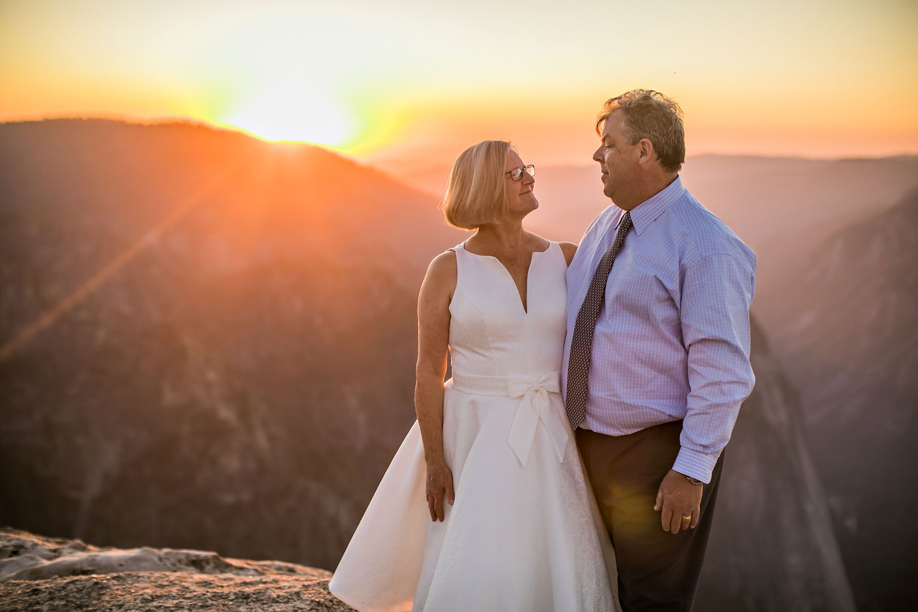 Wedding couple in love at Taft Point in Yosemite for adventure session photography at sunset.