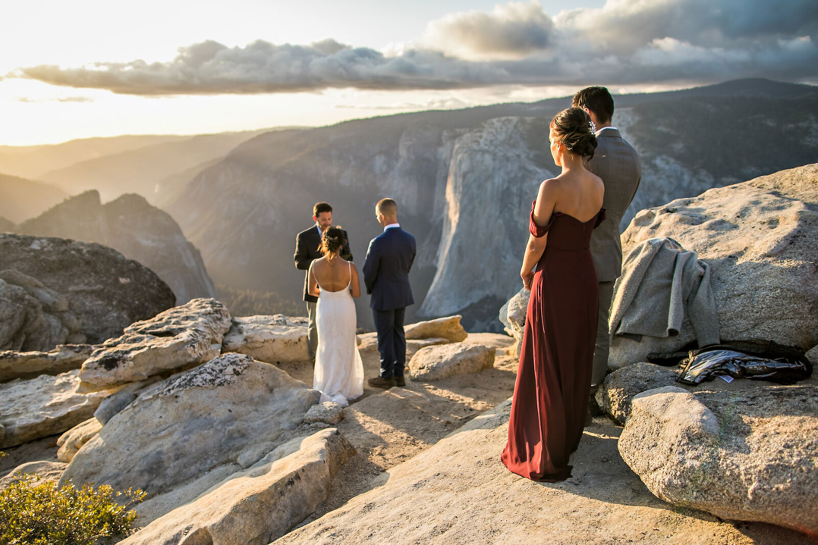 Elopement on cliff edge with friends, bride, and groom.
