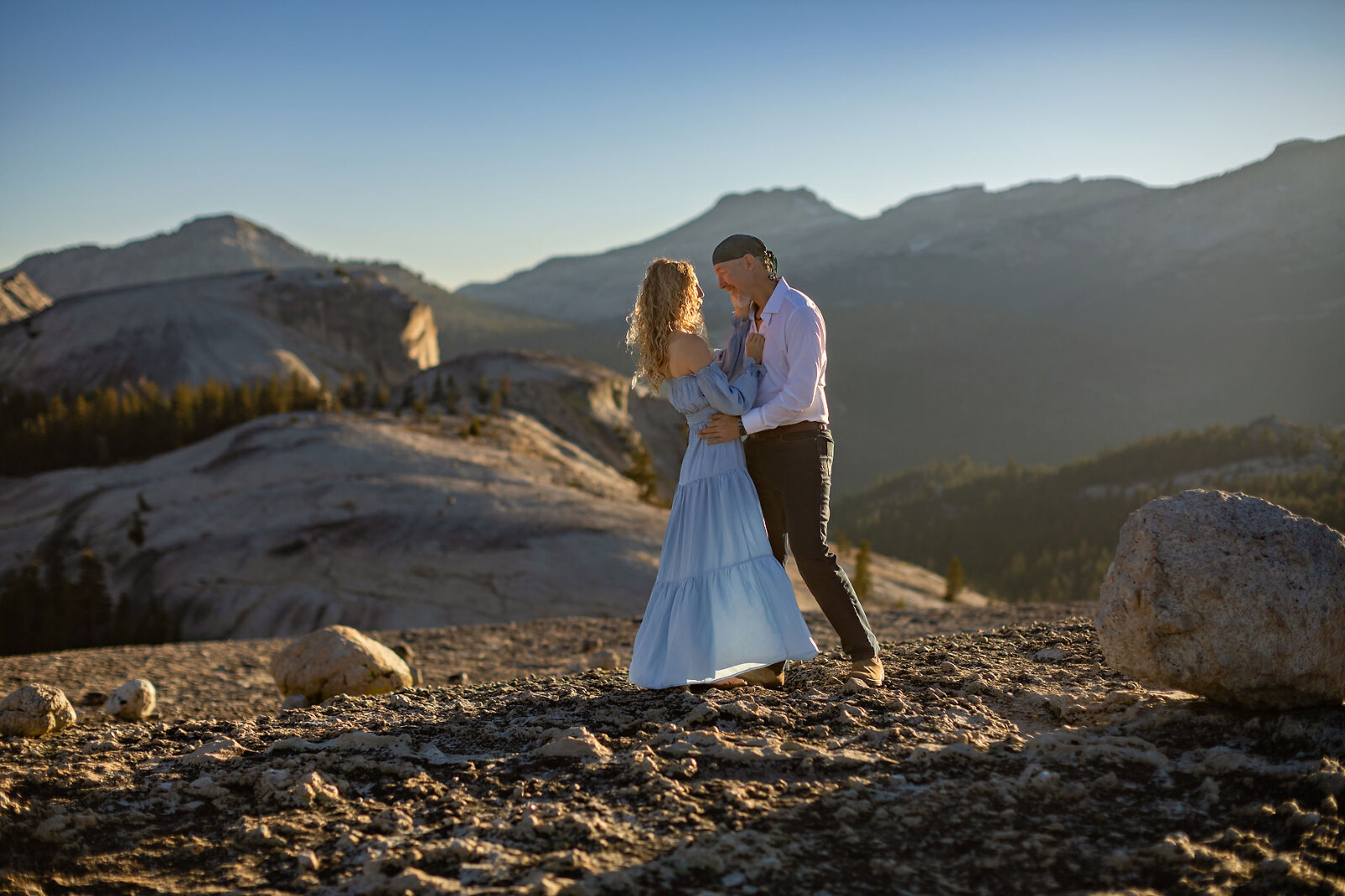 An engagement couple on top of a dome with mountains.