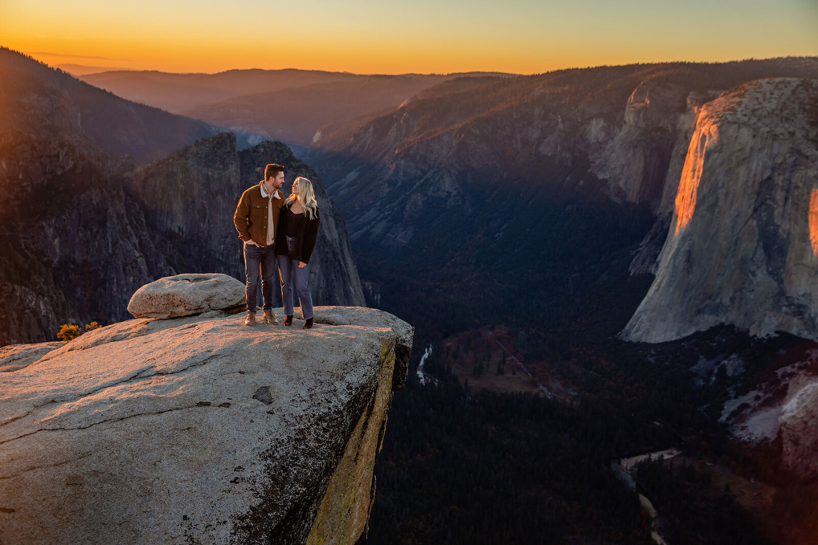 A couple in love on top of mountain during sunset.