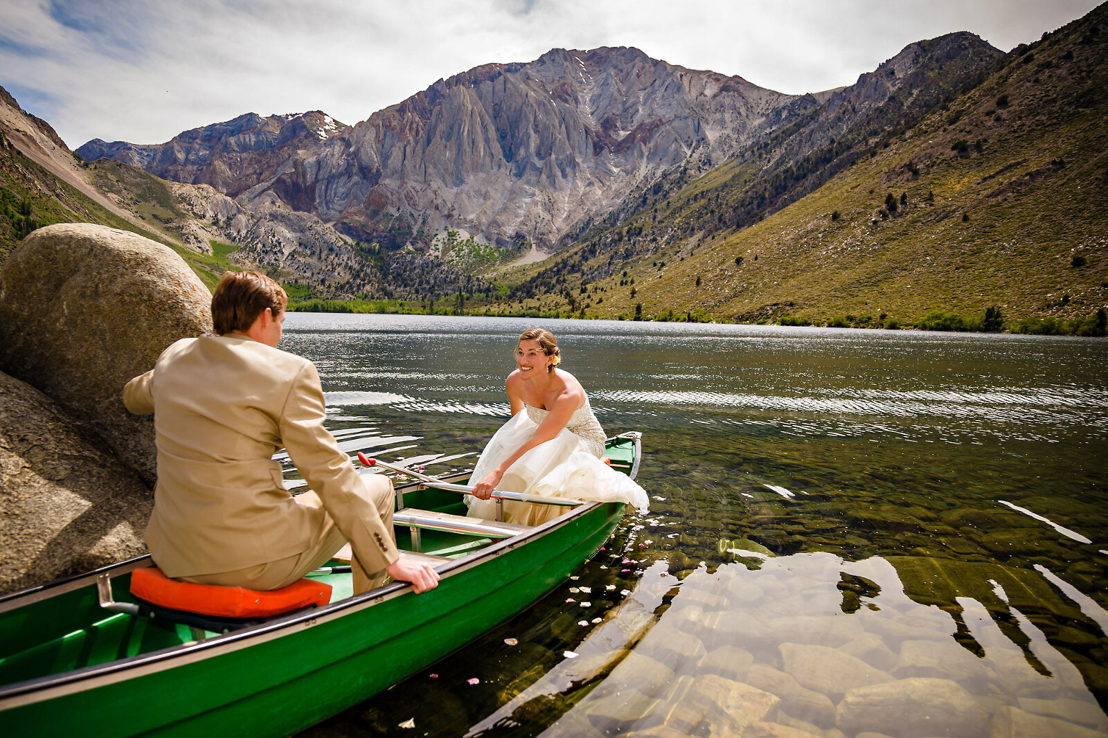 Wedding couple boating on mountain lake