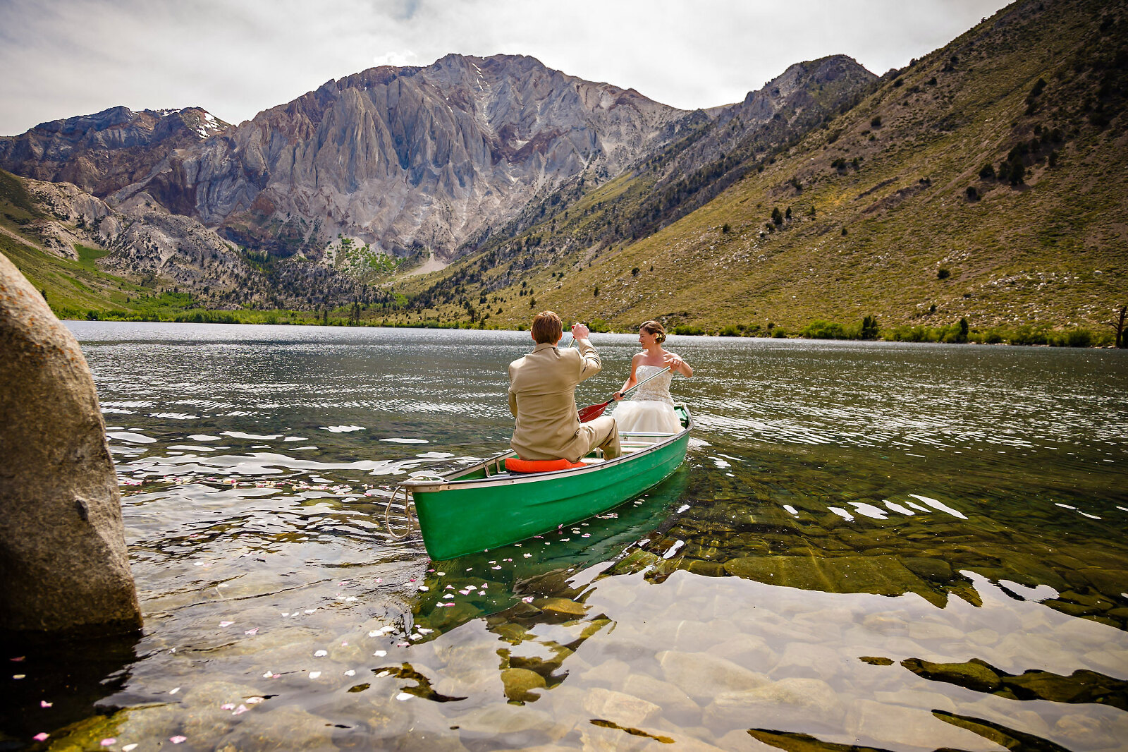 Wedding couple boating on mountain lake
