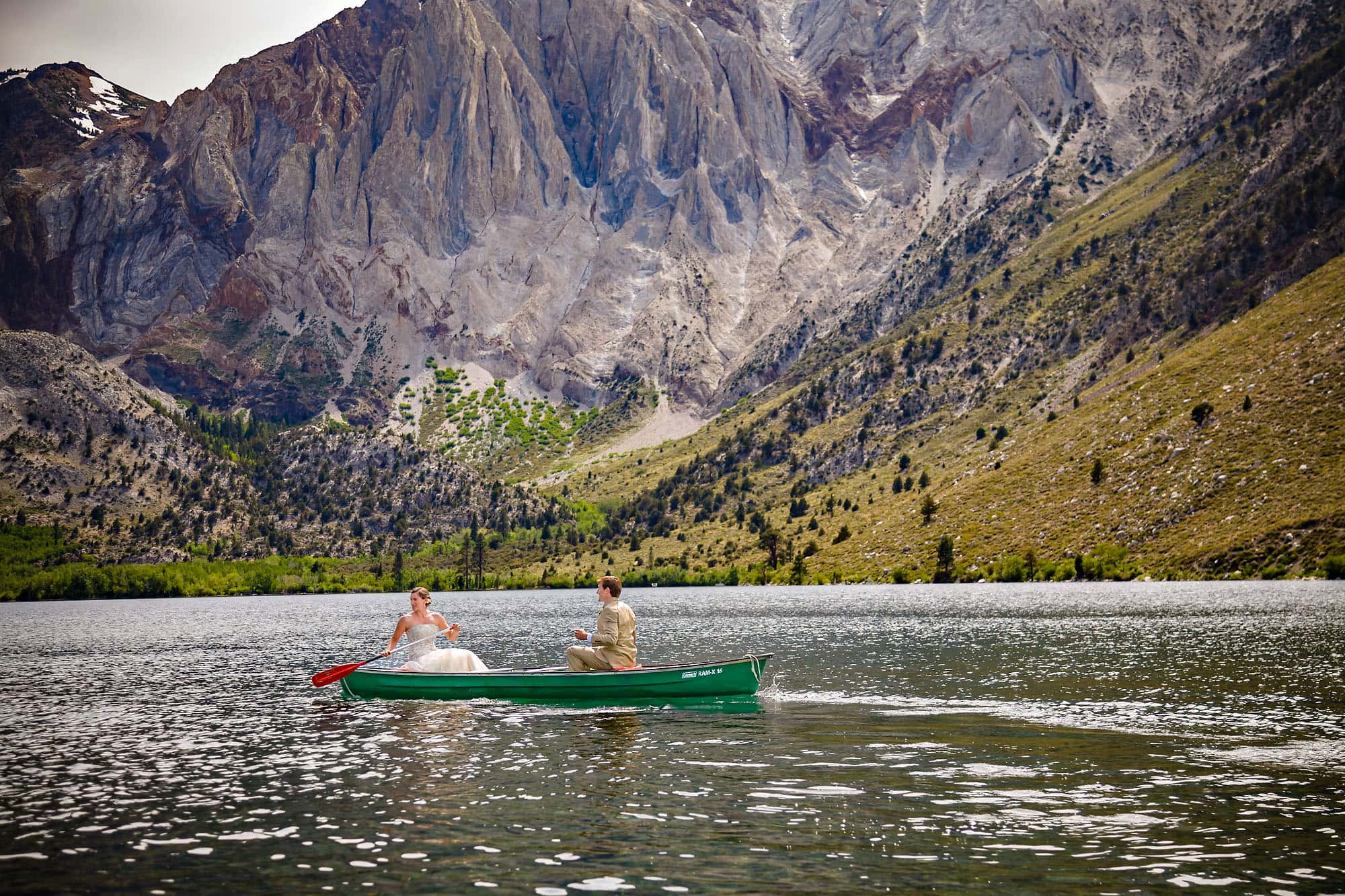 Wedding couple boating on mountain lake