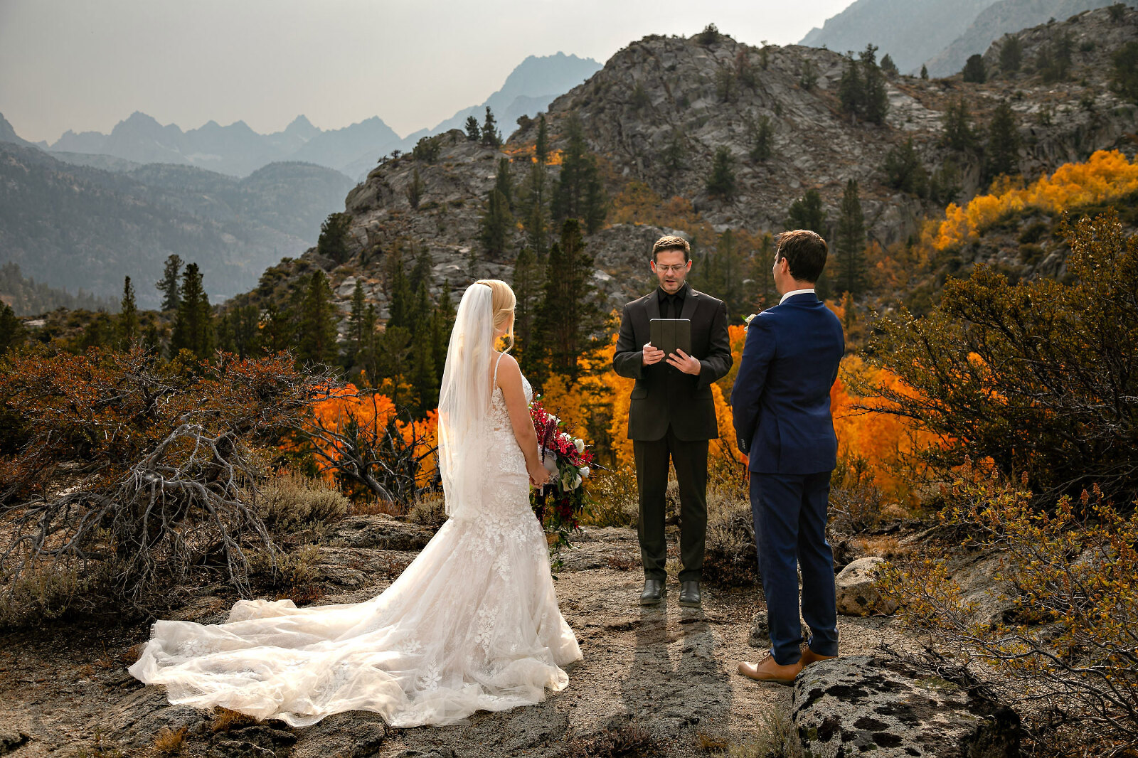 A wedding couple at their intimate wedding saying their vows with mountains.