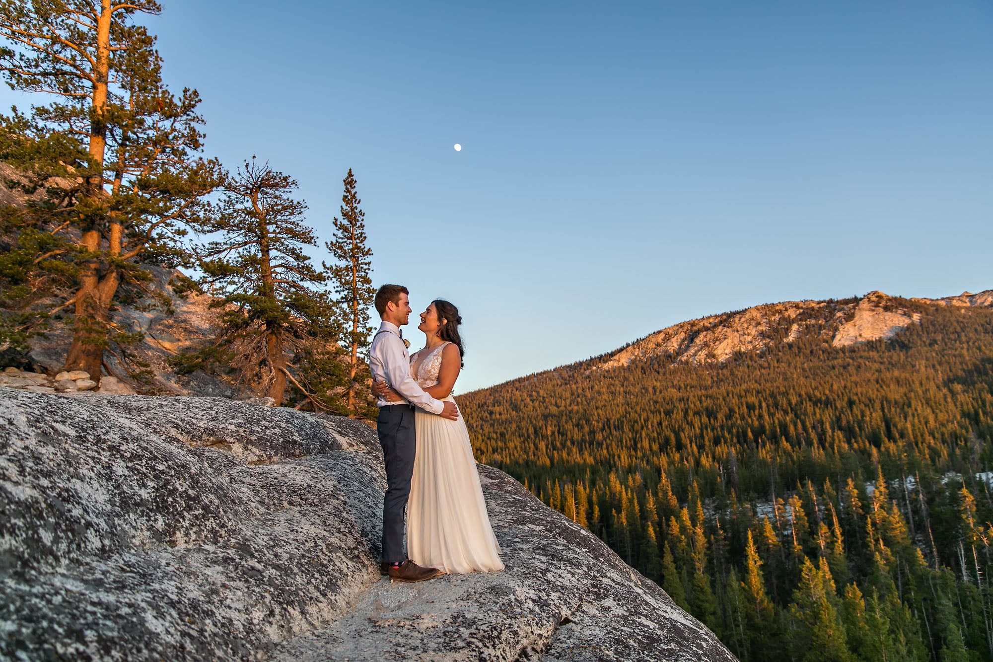 Wedding couple on alpine Sierra dome at sunset.