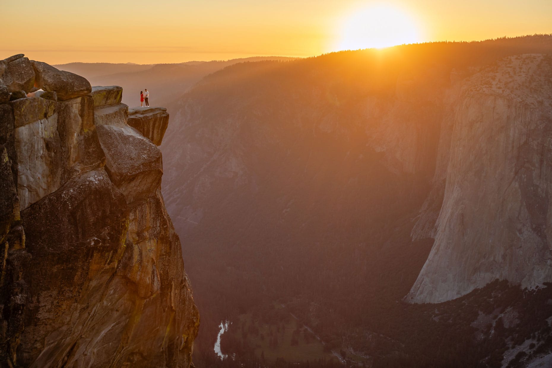 A wedding couple standing on top of a mountain with magical light