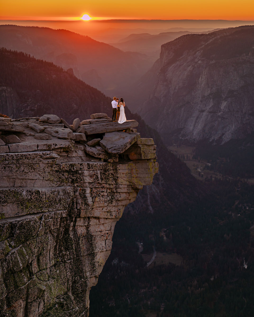 A wedding couple having their ceremony on top of a mountain with magical light