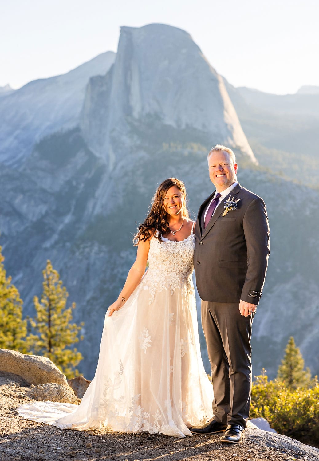 Wedding portrait of bring and groom in sunrise light with mountain in the background.