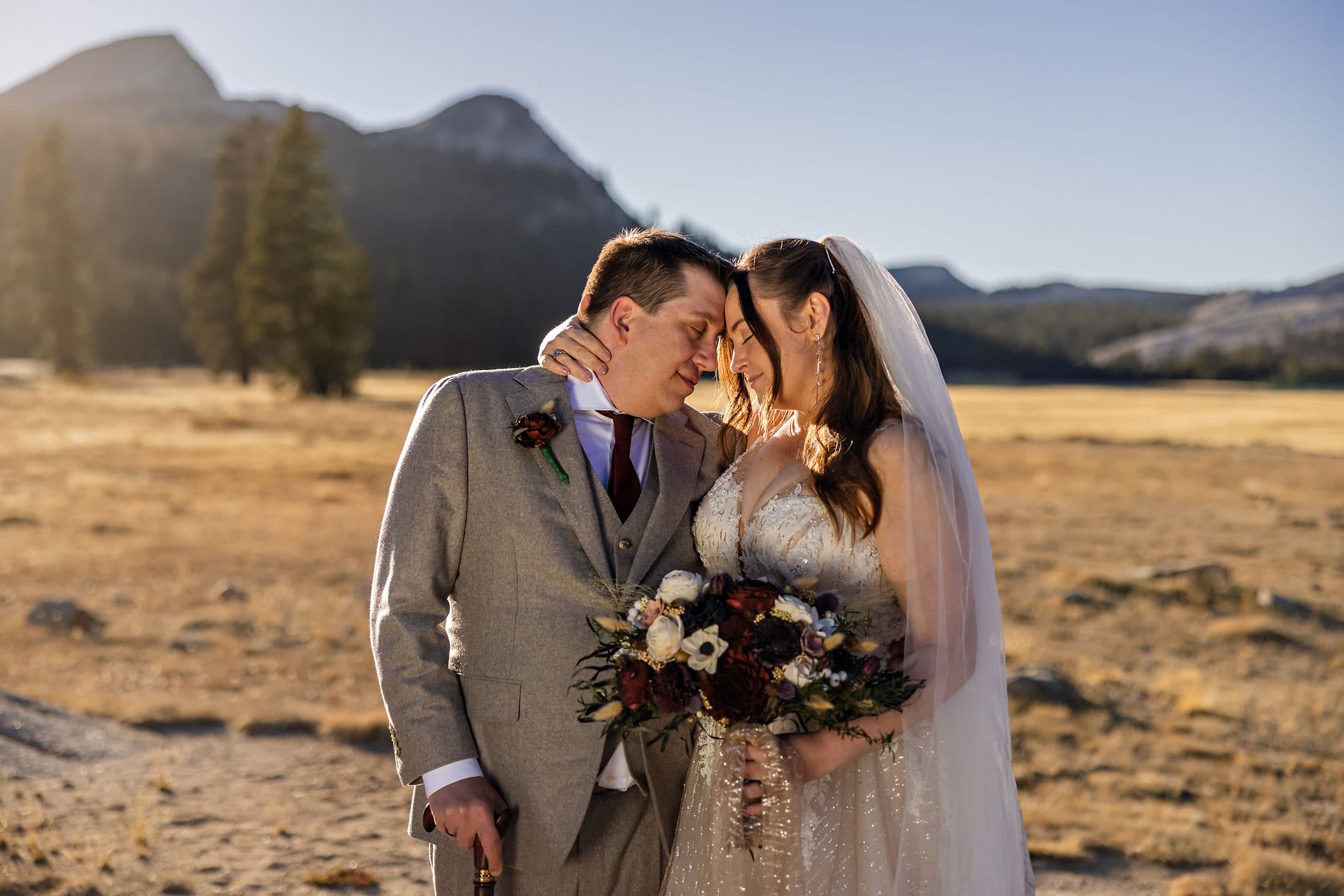 Bride and handicapped groom head to head in golden light on the edge of a meadow.