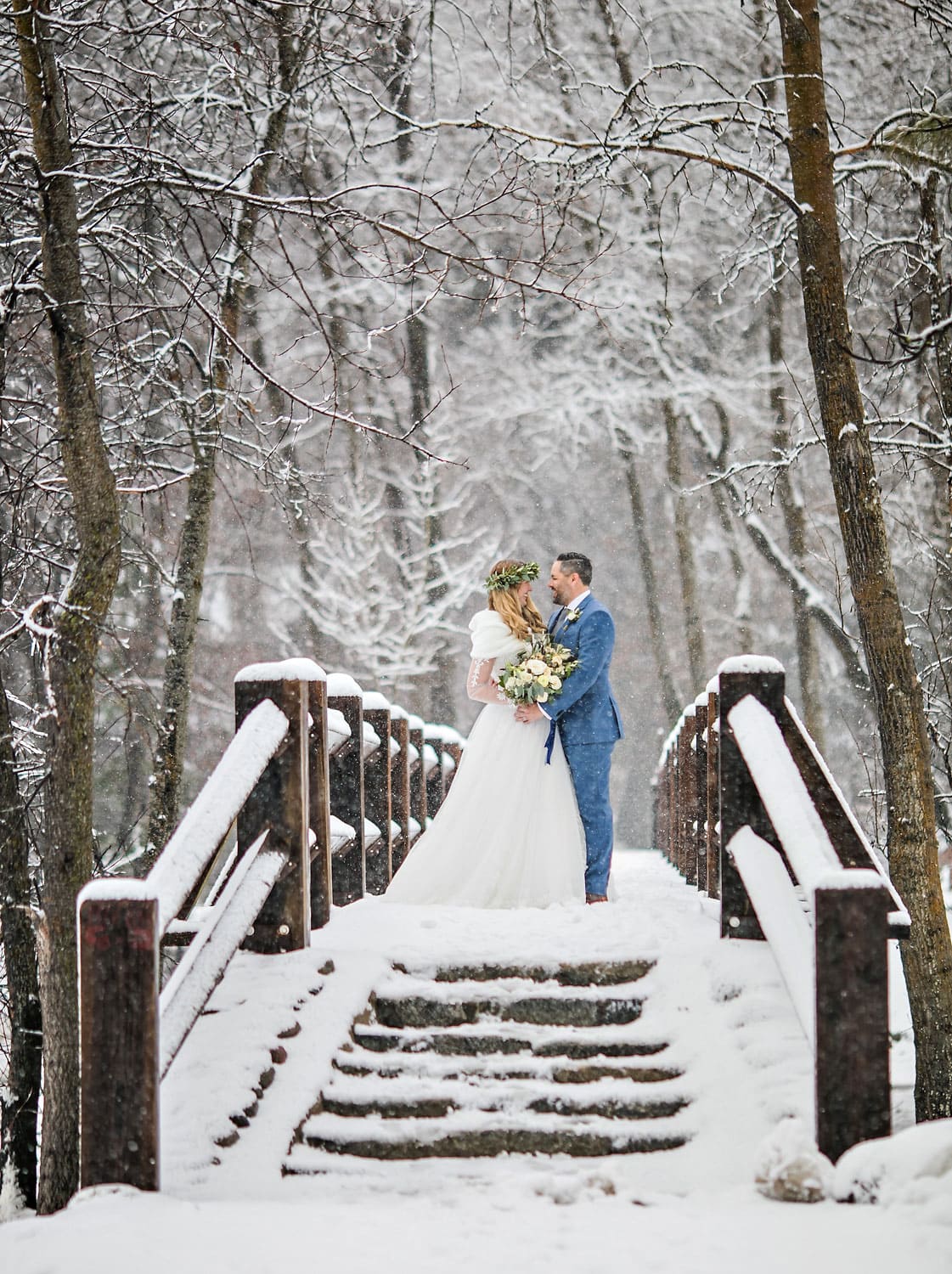 Bride and groom on bridge during a winter wedding.