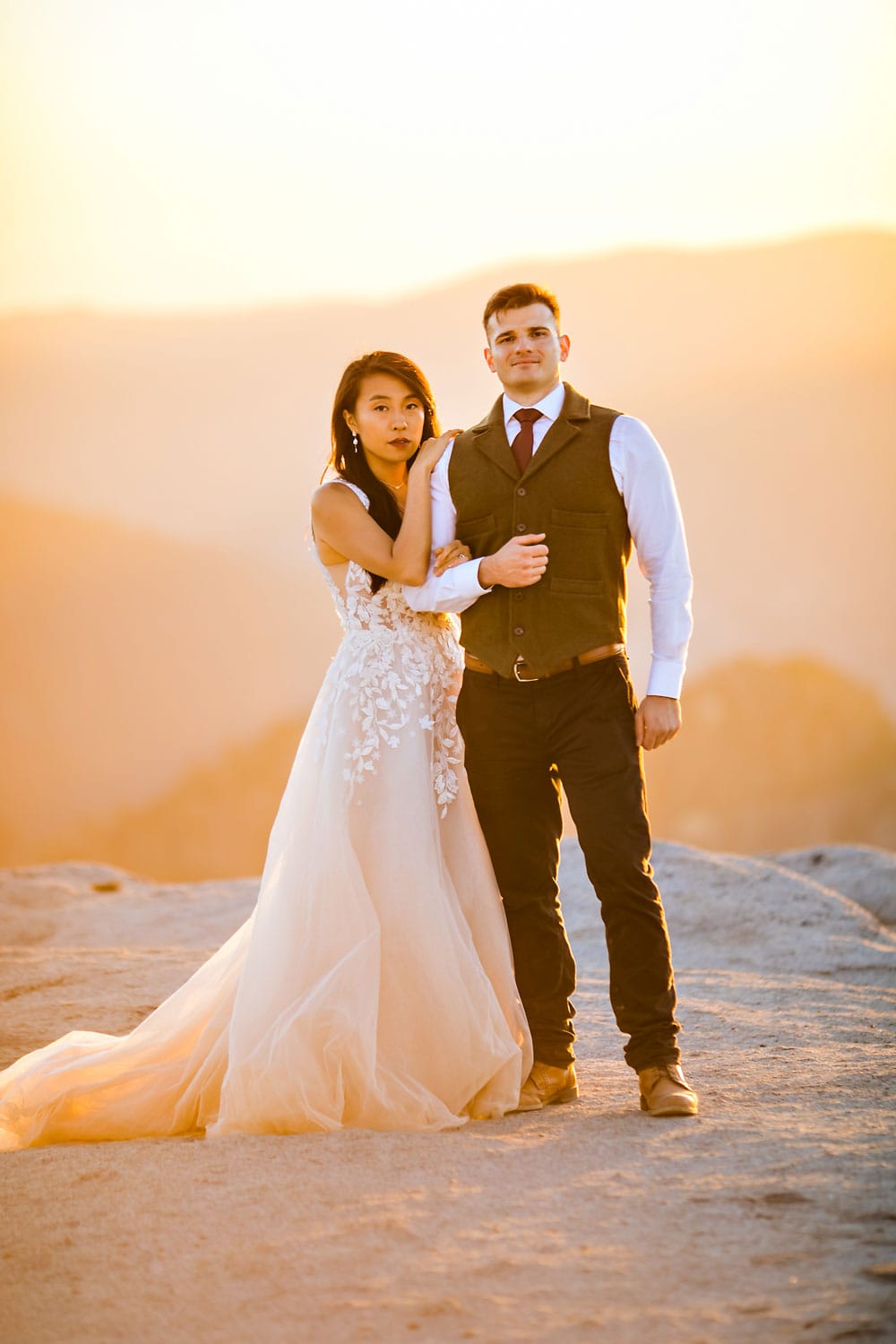 A wedding couple having their ceremony on top of a mountain with magical light
