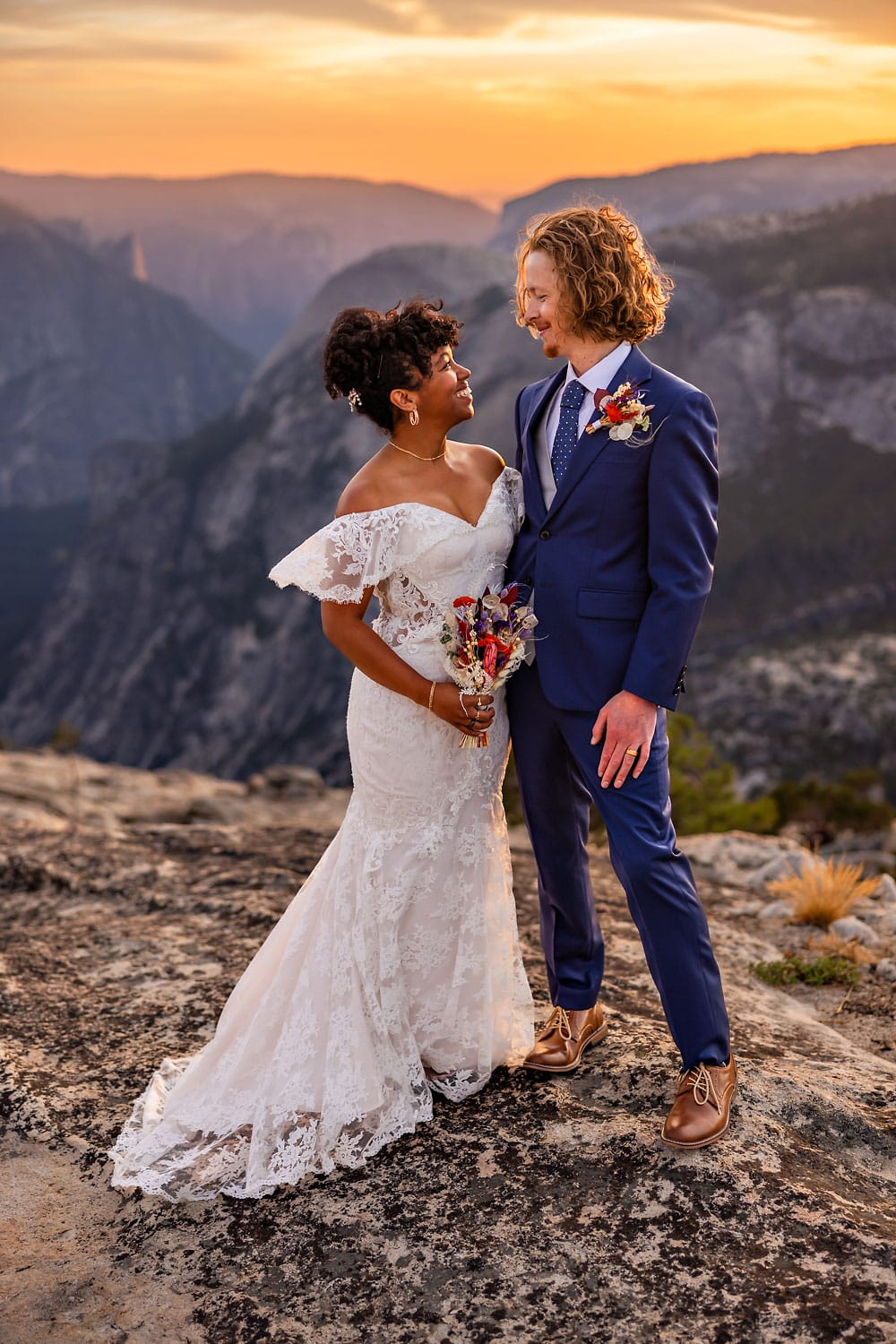 A wedding couple having their ceremony on top of a mountain with magical light