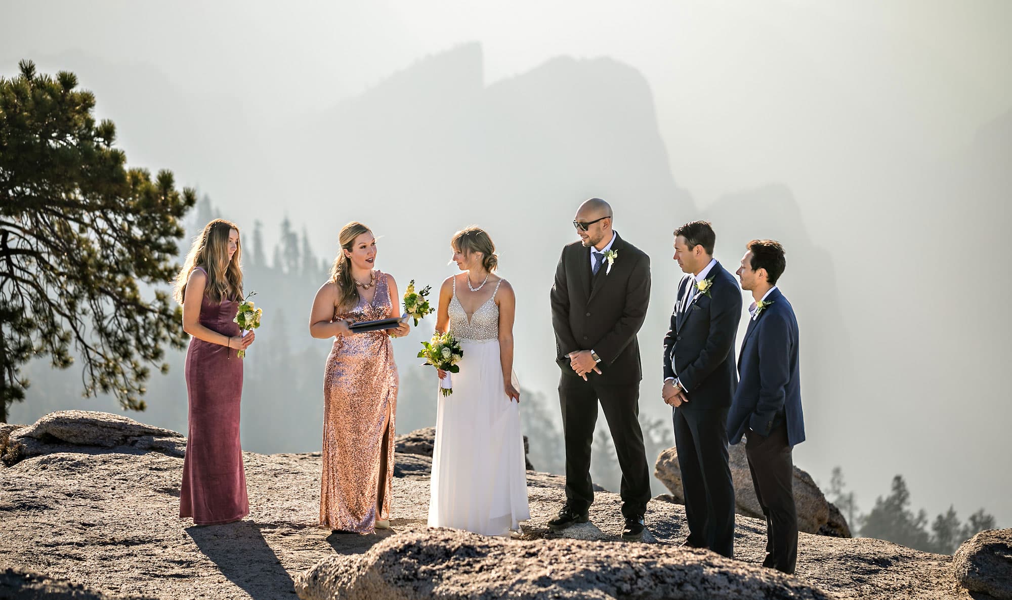 Outdoor wedding ceremony with bridesmaids and groomsmen.